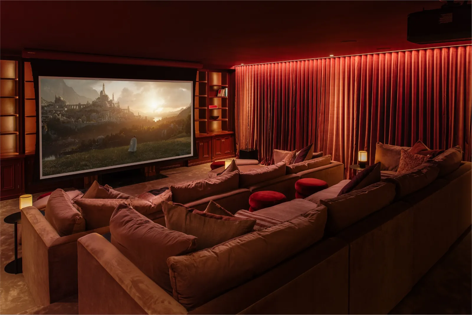 Home cinema with tiered seating, red curtains and low-level lighting